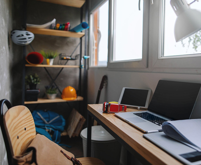 A home workspace with a laptop, tablet, and virtual reality headset on a desk, symbolizing the digital environments where online exploitation can occur.